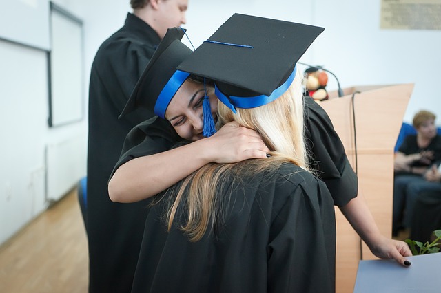 two women hug at graduation