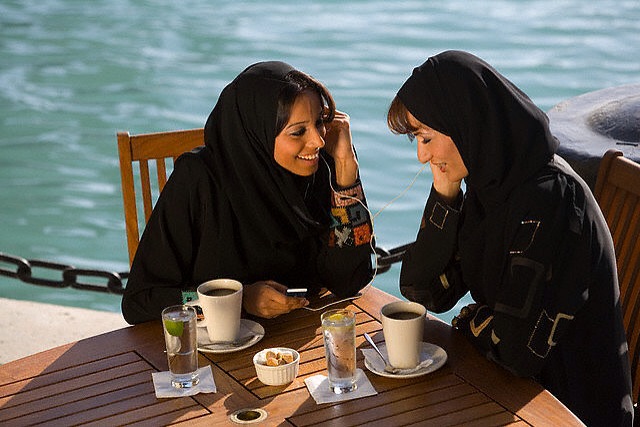 Women Listening to an MP3 Player Over Coffee