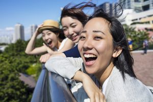 Portrait of three young Japanese girls having fun outdoors.