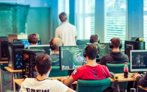 young people in room on computers playing e-sports